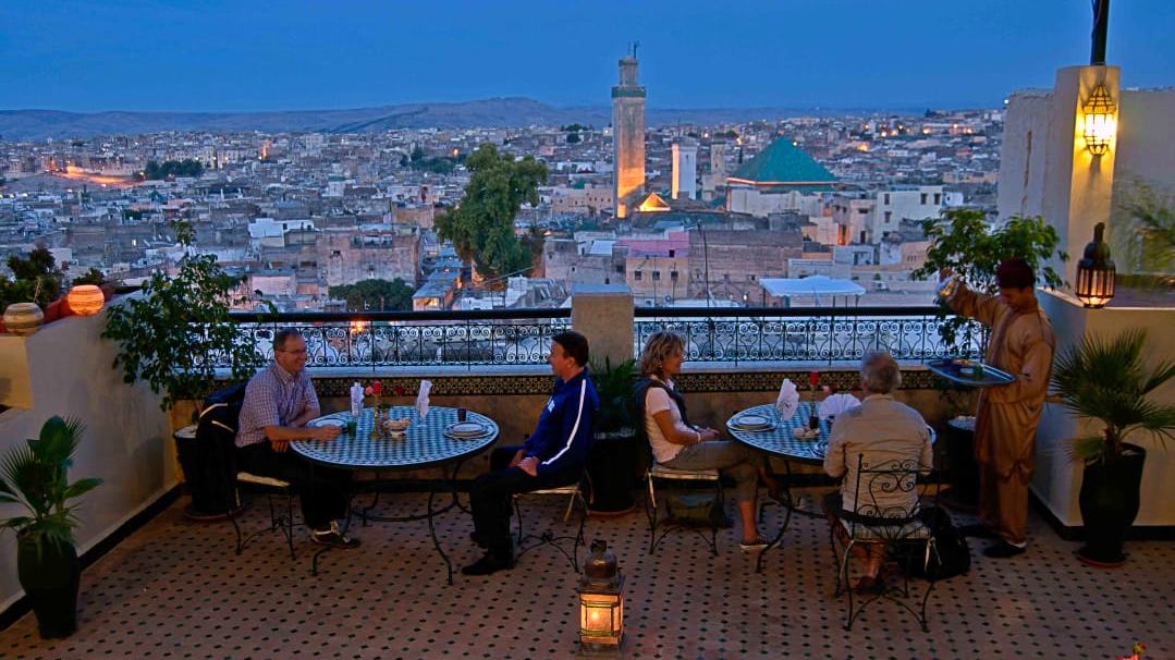 Terrasse du Palais Fès Yahya au crépuscule, vue sur la Médina de Fès et son minaret