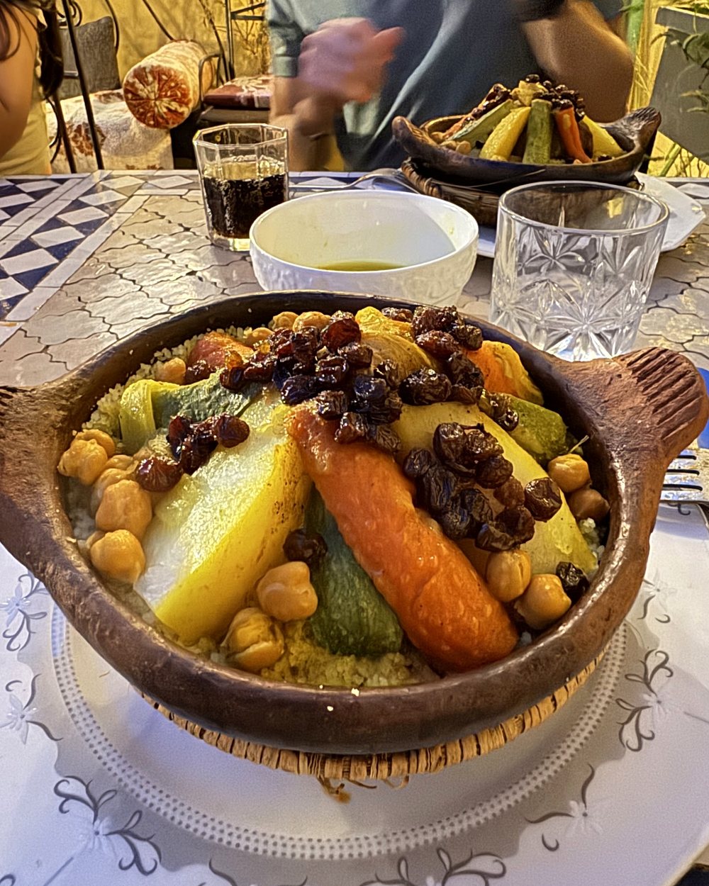 Tajine de légumes aux pois chiches et raisins secs servi à table