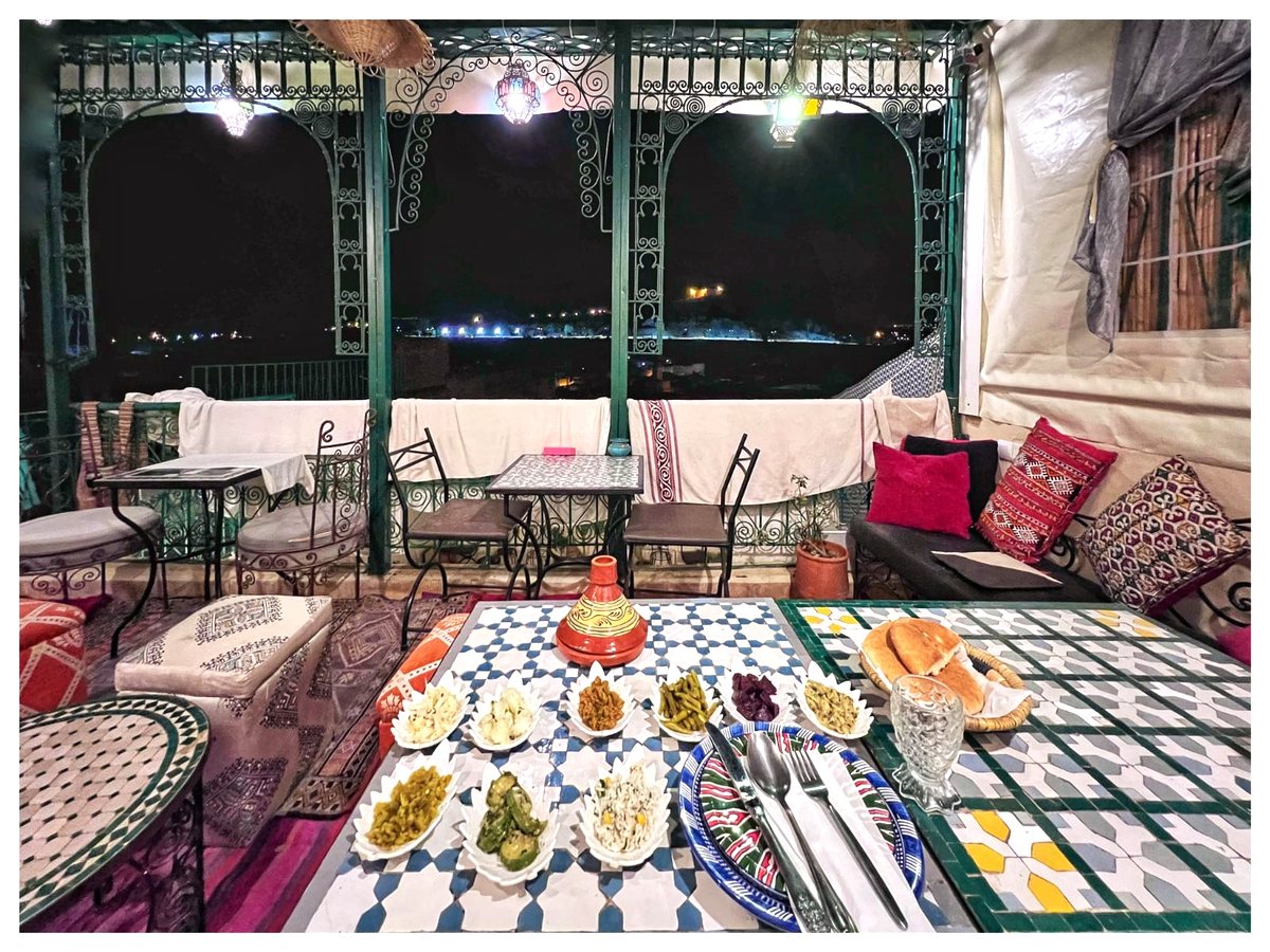 Terrasse dressée le soir sous la pergola et les lanternes